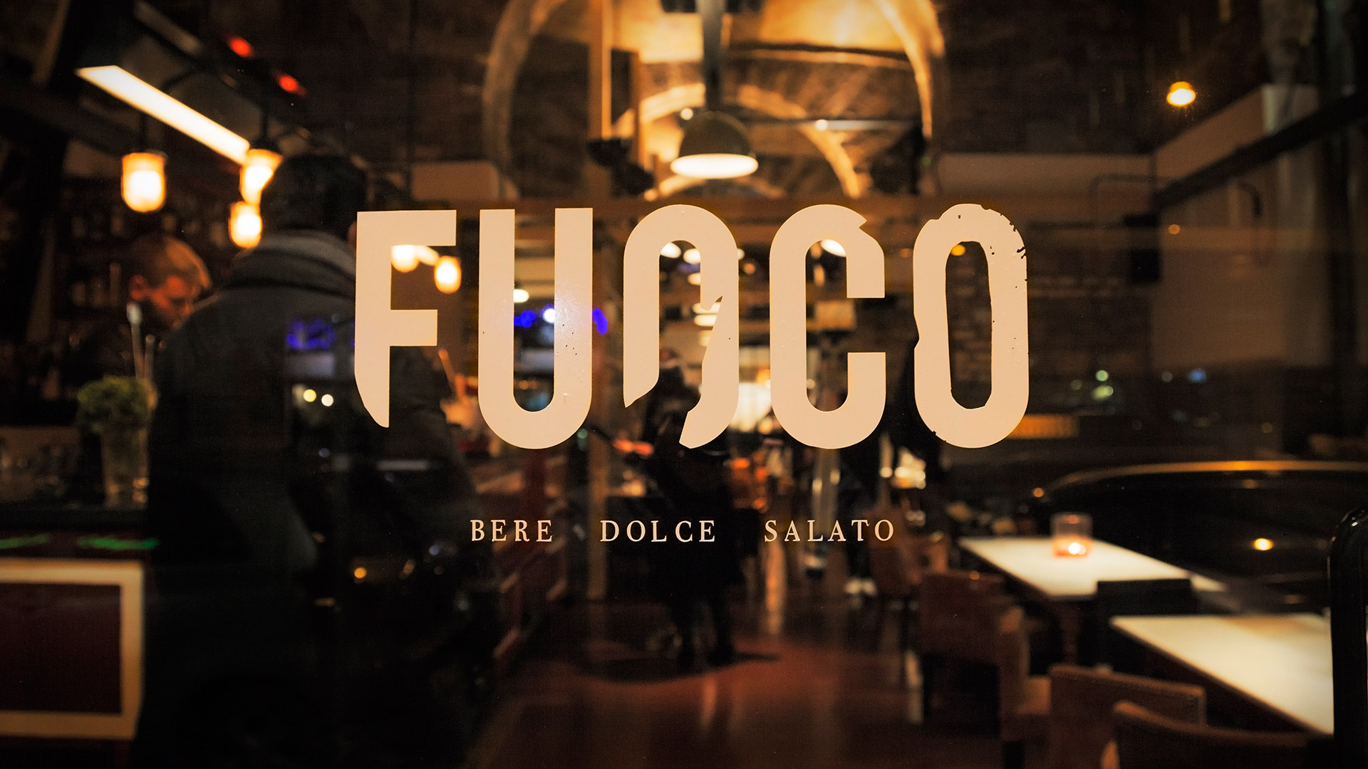 La vetrina di FUOCO con la scritta FUOCO — Bere, Dolce, Salato e la sala illuminata sullo sfondo